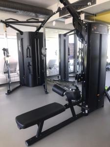a gym with a bench and a simulator at The Olive Beachfront Apartment & Spa in Bahçeli