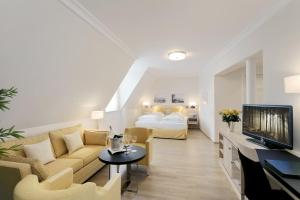 a living room with a couch and a bed at Hotel Bayerischer Hof in Lindau