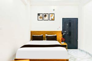 a bedroom with a bed and a black door at Hotel O Karaudi Marg Chittaipur Varanasi in Varanasi