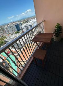 uma varanda com uma mesa de madeira e um banco numa varanda em Amazing Sunrise Venice Grand Canal Balcony, Xbox Series X console with Game Pass Ultimate, FREE coffee, Pool, Gym & Sauna, 5 mins to BGC em Manilla