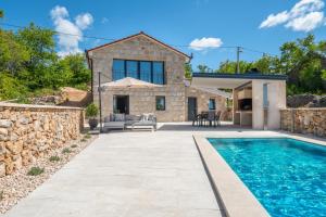 a stone house with a swimming pool and a patio at Hideaway Stonehouse pool for 2 Dalmatia Imotski in Medvidovići