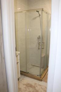 a shower with a glass door in a bathroom at Apartman Ena in Bileća +19 photos