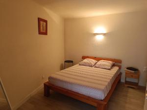 a bedroom with a bed and a light on the wall at Maison de campagne in Saint-Julien-de-Valgalgues
