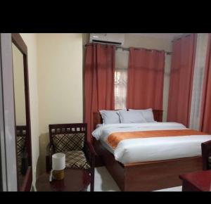 Lizab Lodge的一间卧室，有一张床和一扇带红色窗帘的窗户