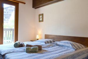 Un dormitorio con una cama con sábanas azules y una ventana. en Résidence Arnica 3 pièces, en Nendaz 12 fotos más