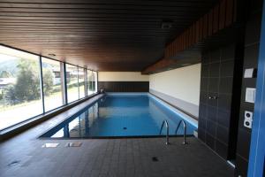 una piscina en un edificio con un gran ventanal en Résidence Arnica 3 pièces, en Nendaz