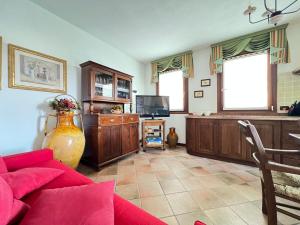 a living room with a red couch and a tv at Villa Oasi Mariuccia - Relax e Mare in Lido di Jesolo