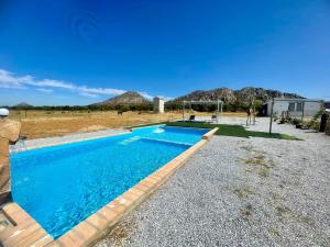 a swimming pool in the middle of a yard at Casa Rural MaciasDehesa in Mérida