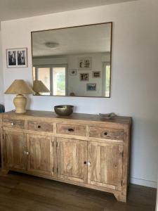 a wooden dresser in a room with a mirror at Chez Thierry - appartement vue mer grande terrasse in Saint-Aygulf