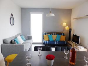 - un salon avec une table et des verres à vin dans l'établissement Appartement 6 voyageurs, terrasse, piscine et parking privé, à Fréjus