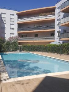 une piscine vide en face d'un bâtiment dans l'établissement Appartement 6 voyageurs, terrasse, piscine et parking privé, à Fréjus