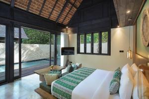 una camera con un grande letto e una piscina di The Sebali Penida Beach Resort a Nusa Penida Altre 125 foto