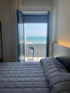 sypialnia z łóżkiem i widokiem na plażę w obiekcie Hotel Il Caminetto w mieście Porto San Giorgio