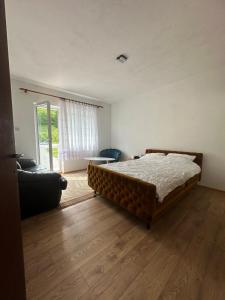 a bedroom with a bed and a living room with a couch at Mirina village house in Pljevlja +22 photos