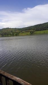a view of a large lake with a wooden railing at Villa Belgium in Rwesero