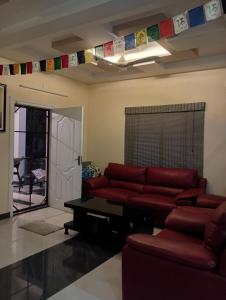 een woonkamer met een rode bank en een tafel bij Dolphin villa Beach Resort in Alleppey +24 foto's