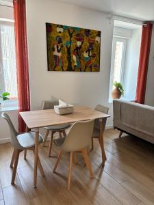 una mesa de comedor con sillas y una pintura en la pared en La case sénégalaise, en Cholet 12 fotos más