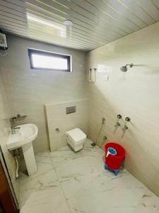 a bathroom with a toilet and a sink at Hotel Shri Goverdhan in Bahraich