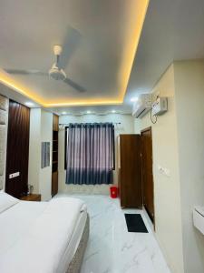 a bedroom with a large white bed and a window at Hotel Shri Goverdhan in Bahraich +3 photos