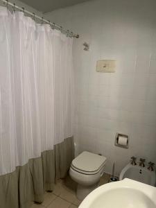 Un baño blanco con inodoro y lavabo. en Departamento 54, en La Plata