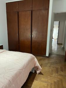 Un dormitorio con una cama y un armario de madera. en Departamento 54, en La Plata