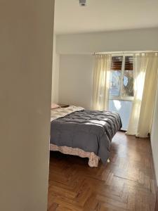 Un dormitorio con una cama y suelo de madera. en Departamento 54, en La Plata