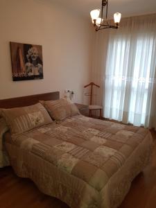 a bedroom with a large bed and a window at Alojamiento Misericordia in Viveiro