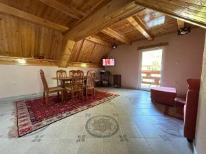 a living room with a table and chairs and a couch at Guest house Crvenkapa in Gusinje