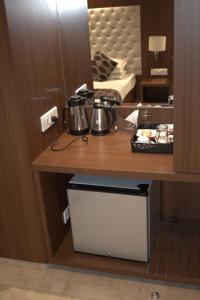 ターネーにあるHotel Sai Sanidhyaの鍋とフライパンが備わるホテルの部屋のテーブル