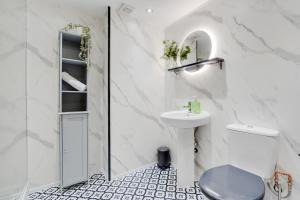 a white bathroom with a sink and a toilet at Liverpool Warehouse Flat - Sleeps 5, WiFi, Free On-Site Parking in Liverpool +39 photos