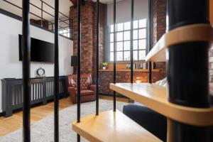 a living room with a couch a chair and a television at Liverpool Warehouse Flat - Sleeps 5, WiFi, Free On-Site Parking in Liverpool
