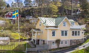 a yellow house with a flag on a hill at Fantastic location on the West Coast, Bohuslän! in Ljungskile