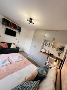 ein kleines Zimmer mit einem Bett und einer Couch in der Unterkunft Newly renovated En-Ensuite Private Room with own Kitchenette in Birmingham - Halesowen R4 in Sleightholme