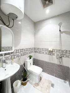 a white bathroom with a toilet and a sink at شقق راقية بأثاث حديث وراقي 1 in Dammam +63 photos