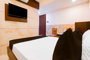 a bedroom with a bed and a tv on a wall at Hotel O Kalyan East in Mumbai