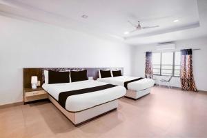 a bedroom with two beds and a window at Hotel O Mahableshwar Uptown in Mahabaleshwar