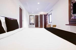 a bedroom with a large white bed in a room at Hotel O Mahableshwar Uptown in Mahabaleshwar +18 photos