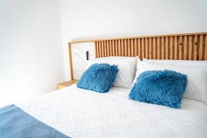 two blue pillows sitting on top of a bed at O da Sina- Los refugios del capitán PESCADOR in Aldán +17 photos