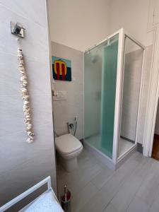 a bathroom with a toilet and a glass shower at Docking House in Lido di Ostia