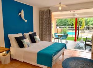 a bedroom with a bed with a blue wall at Charmant studio Orient Bay in Orient Bay