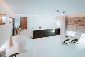 a bathroom with a tub and a sink and a chair at Love & Balneo Week-End in Marseille