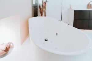 a bathroom with a white sink and shoes on the floor at Love & Balneo Week-End in Marseille