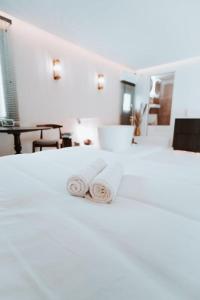 two towels sitting on top of a white bed at Love & Balneo Week-End in Marseille +37 photos