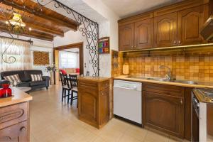een keuken met houten kasten en een woonkamer bij Villa Agia Paraskevi in Ialyssos
