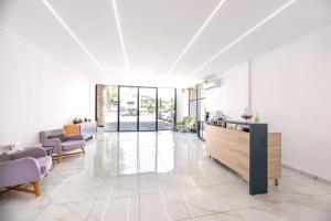 スパタにあるStone Palace Hotel Near Athen's Airport Free Shuttle From and to Athen's Airportのロビー(テーブル、椅子付)が備わる広い客室です。