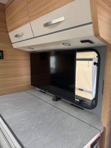 una cucina con TV a schermo piatto in un camper di Premium Wohnwagen Nr 12 im Heide Resort Brüggen a Brüggen