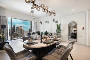 a dining room and living room with a table and chairs at Sky-High Luxury 2BR Burj View Walk Dubai Mall in Dubai