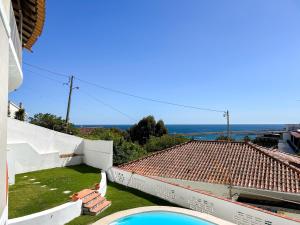 a view from the balcony of a house with a swimming pool at House T3 with Sea View and Private Pool - 5 minutes walk from the beach in Sesimbra