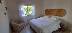 a bedroom with a bed and a chair and a window at Casa Saudade - Oasis Parque Country Club in Portimão +37 photos