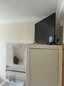a television on top of a cabinet with a sink at Four Seasons Guest House in Canterbury +47 photos